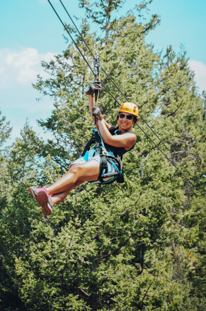 A woman with her legs crossed mid zipline