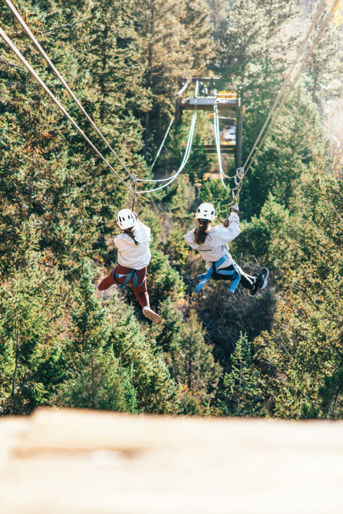 back of two girls ziplining