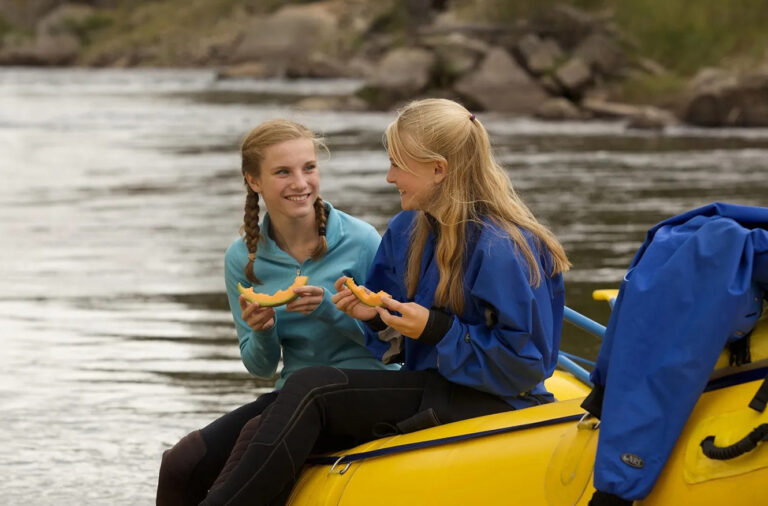 Young girls eating lunch on the river.