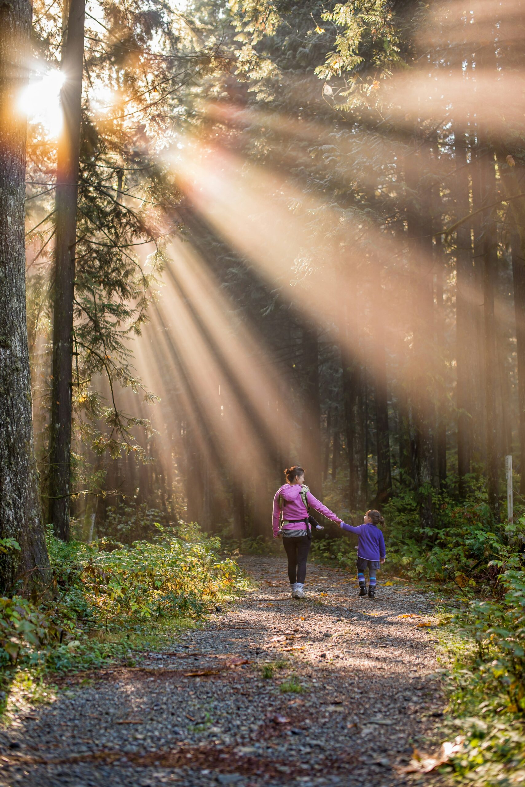 Mother and daughter walking on path outside